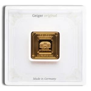 Gold bullion coin by Geiger Edelmetalle, featuring a square design with intricate details, encased in a protective white display holder, labeled "Made in Germany."